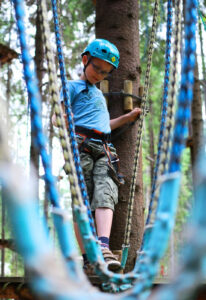 Ze skupieniem i uwagą w parku linowym "Fabryka Endorfiny" w Krynicy-Zdrój w pobliżu Tylickiego Wzgórza